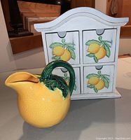 Photo showing the lemon-themed four drawer wooden cabinet and the lemon-shaped vintage pitcher in front