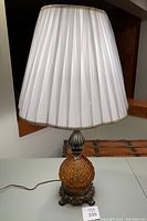 Full view of the lamp with pleated white fabric shade showing its height and intact protective paper.