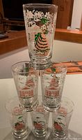 Set of six clear glass tumblers with painted 1940s Southern Belle and Southern house Americana designs, arranged in a pyramid to show different sides.