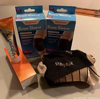 Photo showing the Voltaren gel tube, two boxes of Walgreens Knee Sleeves, and a pair of Stamina support socks