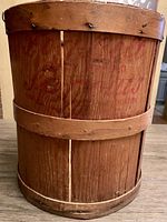 Front view showing large wooden firkin basket with wood staves and three wooden bands, faint red advertising for Fog Belt Sprouts Fancy Graded from Davenport, California visible on side.