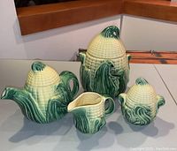 Front view of entire four-piece vintage Stanfordware corn-themed ceramic set including cookie jar, teapot, creamer, and sugar bowl, showing detailed corn kernels and green husks.