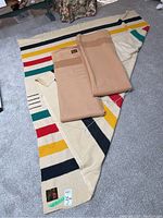 All three blankets laid out: multicolour striped and two folded brown blankets