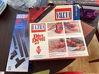 Photo of Dirt Devil Ultra Hand Vac vacuum cleaner packaging and attachments including various nozzles and extension wands.