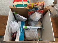 Box containing multiple disposable respirator masks including DEGIL N95 masks and sealed KN95 masks.