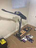 Side view of NordicTrack Pro Plus exercise machine including wooden foot platforms and accessories on floor.