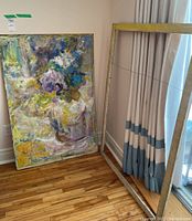 Oil painting still life leaning against wall next to wooden frame, showing overall size and condition.