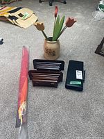 Full lot on floor showing sconce shelves, decorative jar with wooden flowers, kite case, and black putter case.