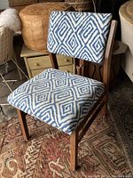 Side angle showing wood frame and pattern of upholstered seat and back