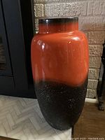 Front and side view of a large vintage West German vase with orange and brown glaze and visible white paint splatters.