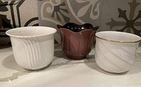 Front view of all three vintage West German pots showing different shapes, colors, and details.