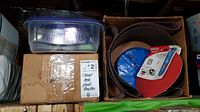 View of sanding belts and grinding discs, including a plastic container with purple lid labeled with 'CEMENT FACELS & PAINT BRUSHES'