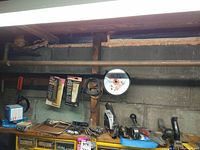 Shelf with staplers, gasket adhesives, staples, hand saw blades, and miscellaneous small hardware items on and above yellow organizer drawers