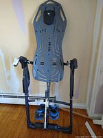Frontal view of gray Teeter inversion table with black frame, ankle supports, and headrest pad.