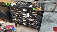 Front view of the metal 5 drawer tool chest showing labeled drawers, metal handles, and items on top shelf