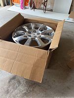 Side view of the Cadillac rim inside a cardboard box.