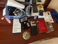 Various electronics, chargers, cables, and small miscellaneous items displayed on a table