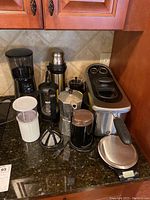 Full view of kitchen countertop with GE deep fryer, Bodum French press, coffee grinder, thermos flask, moka pot, and coffee filter holder grouped together