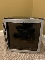 Front view of Magic Chef wine cooler with tinted glass door and visible racks inside.