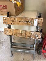 Front view of the Workmate 85 showing wooden folding clamp surfaces and metal frame base with brand markings.