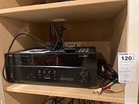 Yamaha RX-V479 receiver with cables on a shelf, original box visible, showing connection ports and front panel controls.