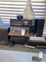 Multiple Yamaha speakers, Pioneer receiver, turntable, and other audio equipment photographed on a table with cables and a remote control.