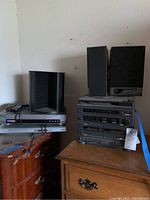 Photo showing the Electro brand cassette stereo main unit with multiple decks and black bookshelf speakers.