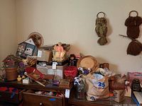 Full view of the lot showing birdhouses, owl wall hangings, doll, baskets and picture frames on shelves and floor.