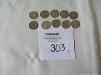 Ten circulated Canadian silver dimes arranged in two rows above auction lot paper. Coins show varying levels of wear.