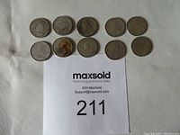 Top view of all 10 Canadian silver dimes arranged in two rows on white fabric background showing their circulated condition and varied years.