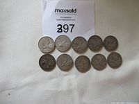 Ten Canadian silver 25-cent coins displayed face-up showing caribou reverse sides with all coins circulated.
