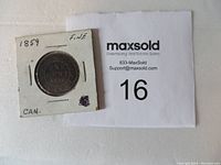 Photo of 1859 Canadian one cent coin in cardboard holder with label showing fine condition