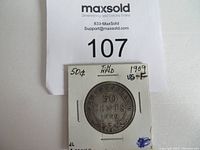 Back view of coin holder with handwritten identification of the 1909 50 cent Newfoundland coin and marked condition.