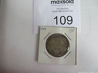 Photo of the 1918 Newfoundland 50 cent silver coin in protective cardboard holder.