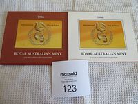 Two original Royal Australian Mint folders for the coin set, one brown and one white, both with International Year of Peace emblem and text stating 1986.