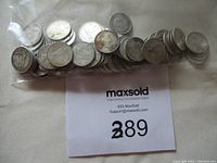 Photo showing a collection of 68 circulated silver dimes primarily from the 1950s and 1960s in a plastic bag on fabric.