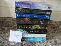 Stack of 8 Louise Penny softcover books, titles and author name visible on spines and covers.