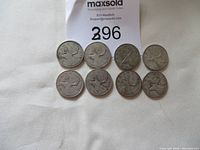 Top view of eight circulated Canadian silver quarters laid out with sale tag visible