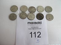 Ten circulated Canadian silver dimes arranged over a MaxSold auction card showing lot number 112.