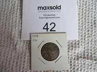 Front side of the worn 1905 Canadian 25 cent silver coin in a white paper flip with handwritten date and denomination.