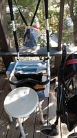 Photo showing white plastic shower stool with aluminum legs and folding black wheelchair