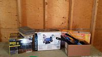 Photo of all items including a boxed 6 inch bench grinder, boxed battery backup onduleur, Lumius LED light, and tools in a box