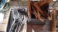 Photo of assorted wooden and cloth-covered hangers in crates, some identified as vintage hotel hangers