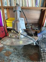 Full view of the metal ceiling light fixture showing the metal components and attached wire.