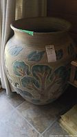 Photo of large planter showing overall shape and decorative leaf patterns around the rim.