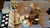 Top-down view of the lot showing porcelain mugs, clear glassware, marble board, tea set, and miniature figures