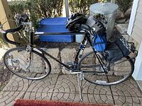 Side view of black Schwinn bicycle with two helmets and accessories attached to rack