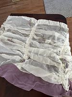 Photo showing white sheer curtain fabric with gathered ruffles and embroidered purple and yellow dragonflies.