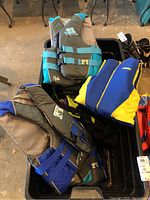 Bin of assorted swim vests showing various colors with adjustable straps