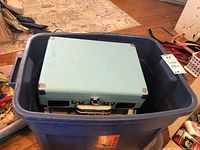 Blue storage bin containing the closed Crosley portable turntable case